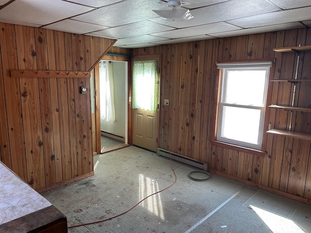 entryway featuring a paneled ceiling, wooden walls, and baseboard heating