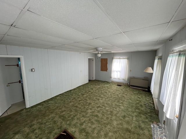 interior space featuring visible vents, dark carpet, a paneled ceiling, and a ceiling fan