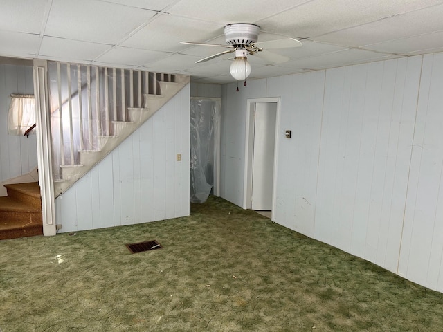 below grade area featuring a ceiling fan, a paneled ceiling, visible vents, and stairway