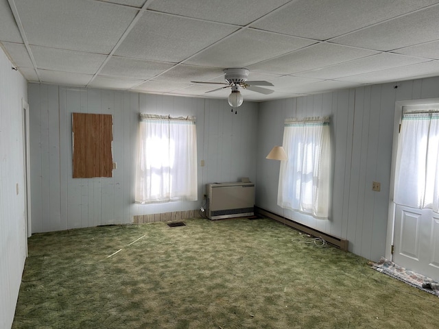 spare room featuring plenty of natural light, visible vents, a drop ceiling, and carpet flooring