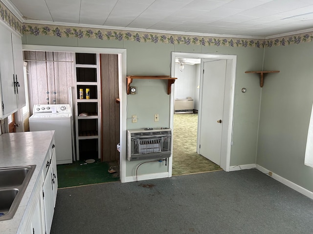 kitchen featuring heating unit, light countertops, dark carpet, washing machine and dryer, and a sink