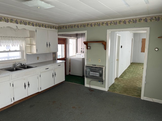 kitchen featuring a sink, white cabinetry, heating unit, dark carpet, and washer / dryer