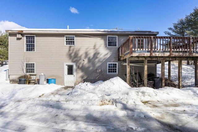 snow covered house featuring a deck