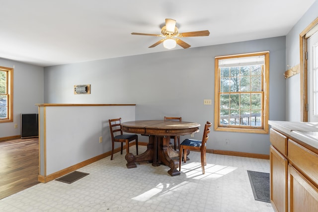 dining room featuring light floors, baseboards, visible vents, and ceiling fan