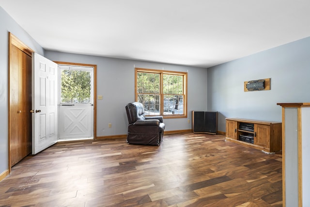 unfurnished room featuring plenty of natural light, wood finished floors, and baseboards