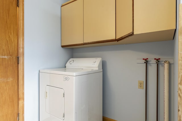 clothes washing area with washer / clothes dryer and cabinet space