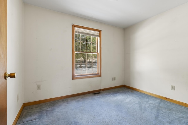 spare room featuring carpet, visible vents, and baseboards