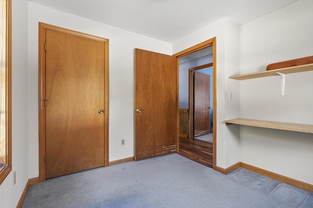 unfurnished bedroom with carpet floors and baseboards