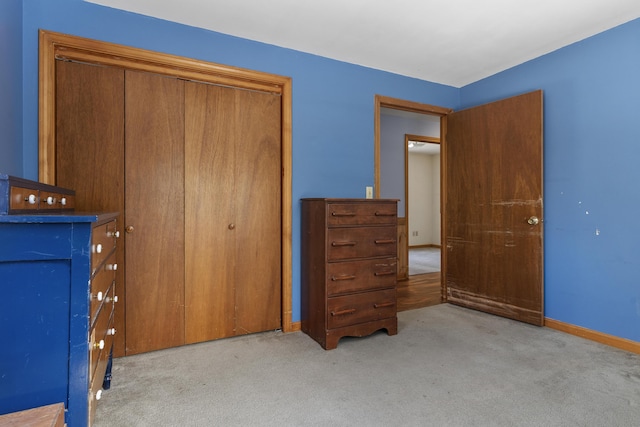 unfurnished bedroom featuring a closet, carpet flooring, and baseboards