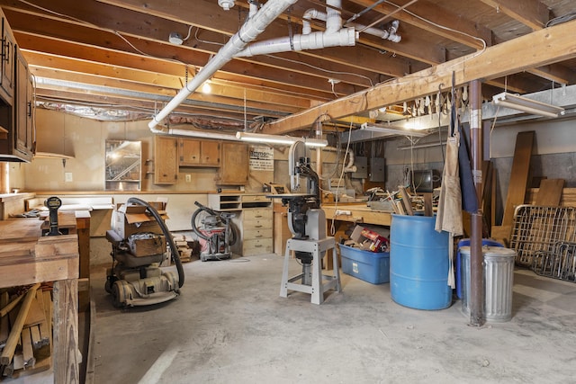 unfinished basement featuring electric panel and a workshop area