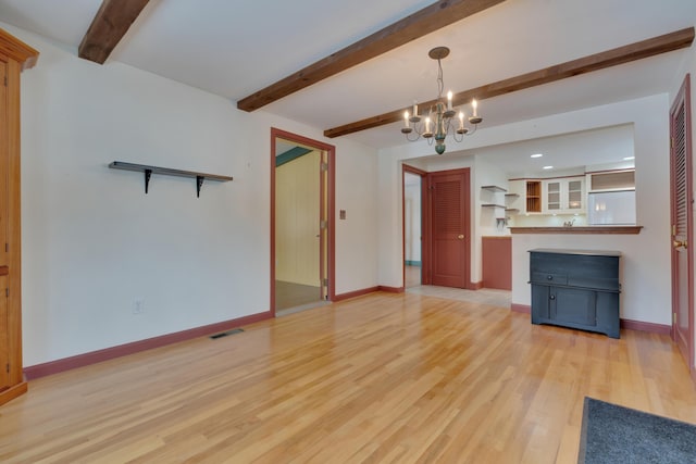 unfurnished living room featuring light wood finished floors, beamed ceiling, visible vents, and baseboards