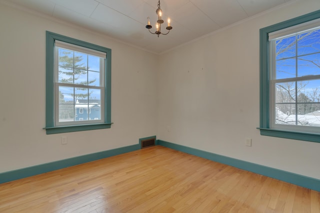 empty room with visible vents, crown molding, and wood finished floors