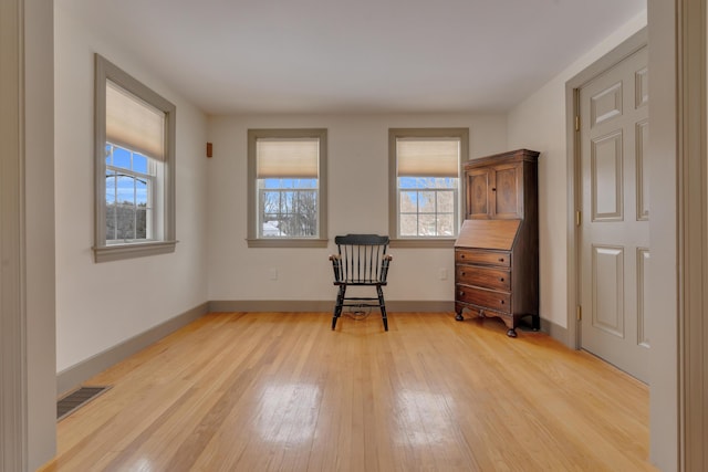 unfurnished room with baseboards, visible vents, and light wood finished floors