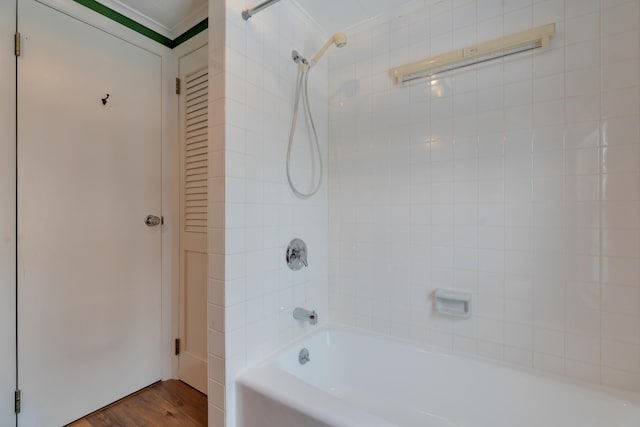 full bath with ornamental molding, shower / washtub combination, and wood finished floors