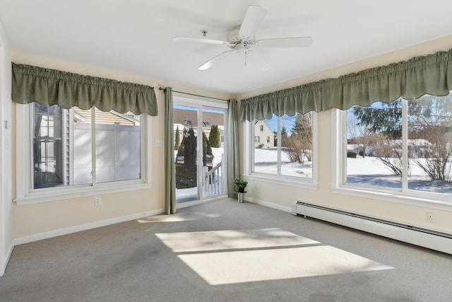 empty room with carpet, ceiling fan, a baseboard radiator, and baseboards