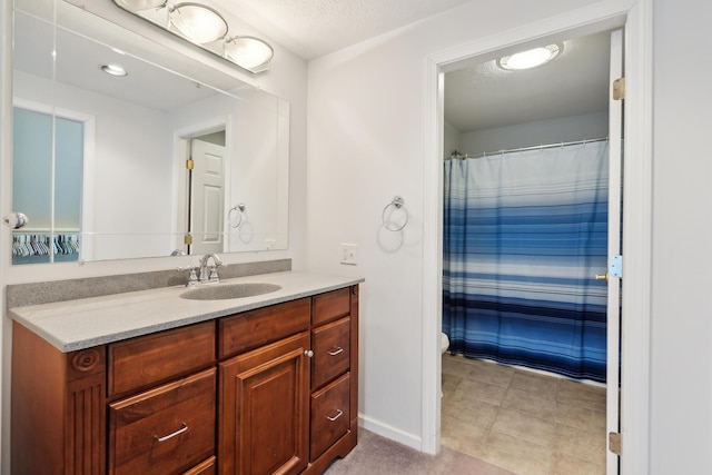 full bath featuring curtained shower, vanity, baseboards, and tile patterned floors