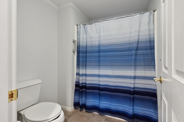 bathroom featuring tile patterned flooring, baseboards, curtained shower, and toilet