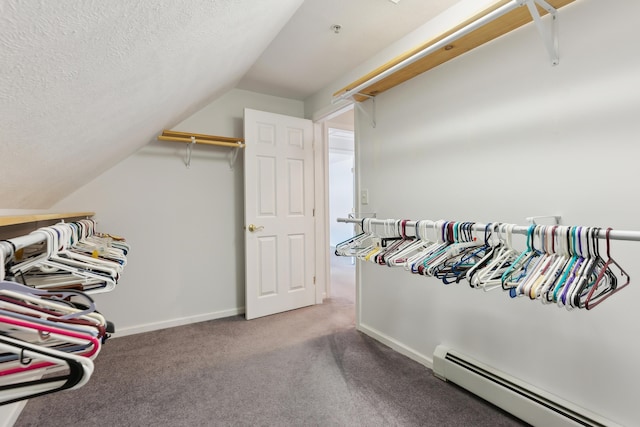 walk in closet with lofted ceiling, carpet, and a baseboard heating unit