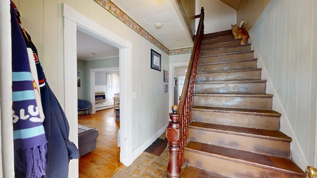 staircase with visible vents, wood finished floors, and ornamental molding