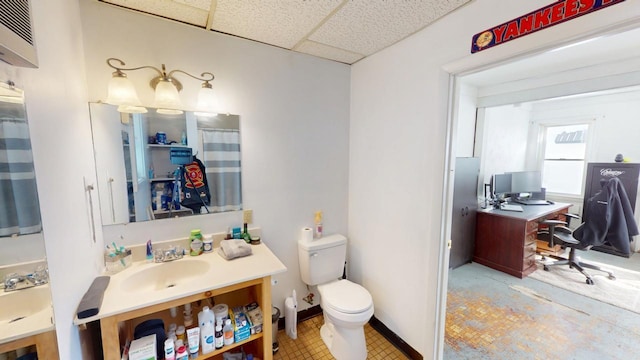 bathroom with toilet, baseboards, a paneled ceiling, and vanity