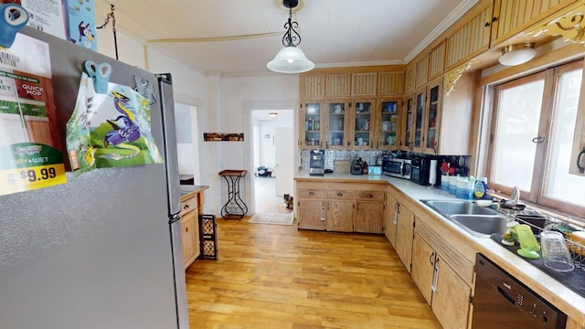 kitchen with crown molding, light countertops, appliances with stainless steel finishes, light wood-style floors, and a sink