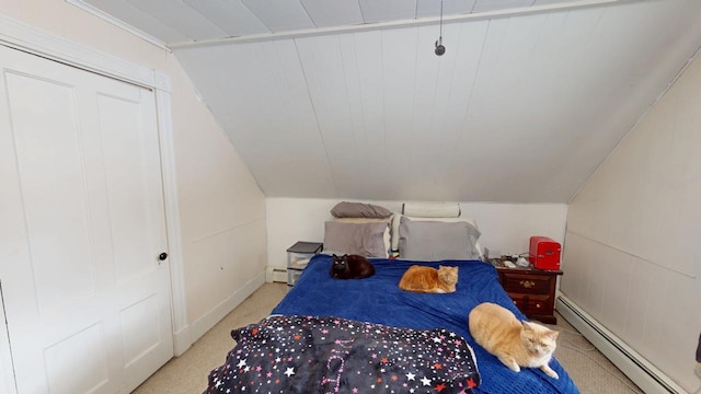 bedroom featuring vaulted ceiling, baseboard heating, and carpet flooring