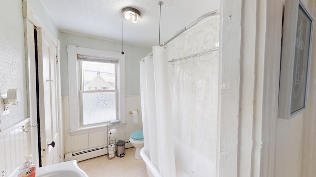 bathroom with a baseboard radiator, toilet, wainscoting, a textured ceiling, and a shower with curtain