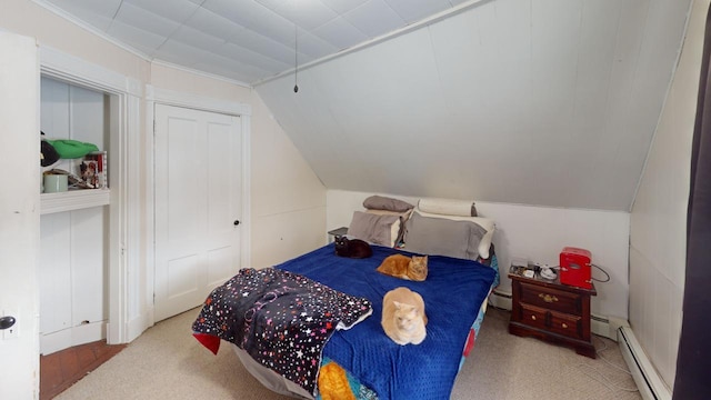 bedroom with carpet, a baseboard radiator, baseboard heating, and vaulted ceiling