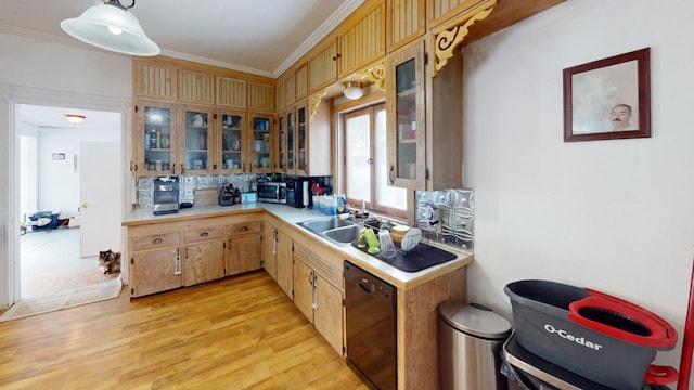 kitchen featuring black dishwasher, light countertops, ornamental molding, a sink, and light wood-type flooring