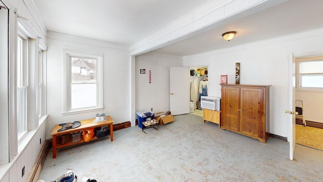 misc room with an AC wall unit, crown molding, and baseboards