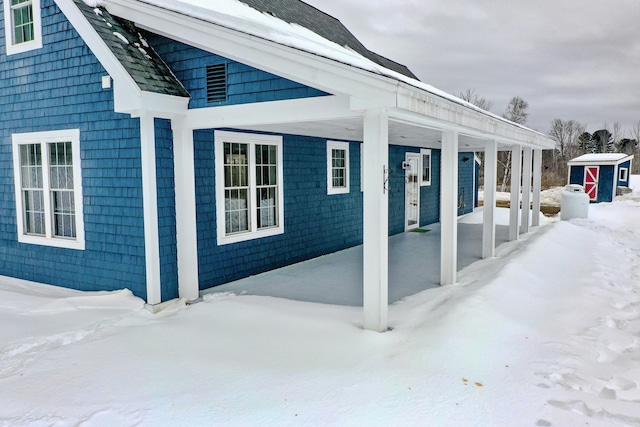 snow covered patio with an outdoor structure