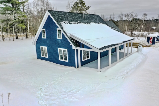 snow covered property featuring an outbuilding