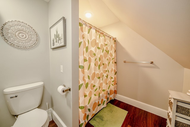 full bathroom with lofted ceiling, curtained shower, toilet, wood finished floors, and baseboards