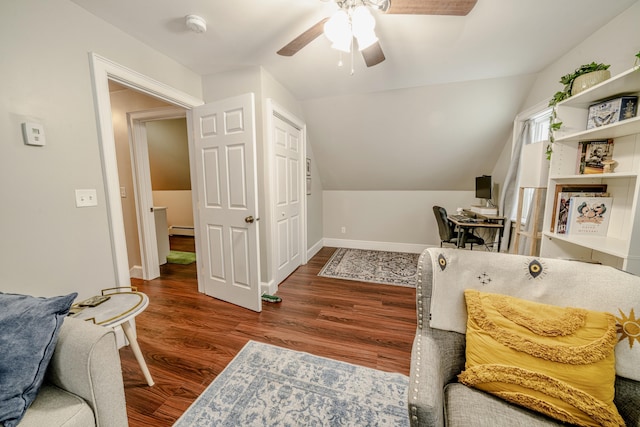 office area with a baseboard heating unit, wood finished floors, a ceiling fan, baseboards, and vaulted ceiling