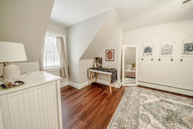 interior space with lofted ceiling, baseboard heating, baseboards, and dark wood finished floors