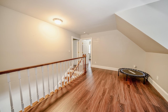 bonus room with lofted ceiling, baseboards, and wood finished floors