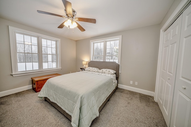 carpeted bedroom with ceiling fan, baseboards, and a closet