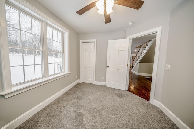 unfurnished bedroom with a ceiling fan, carpet, baseboards, and a closet