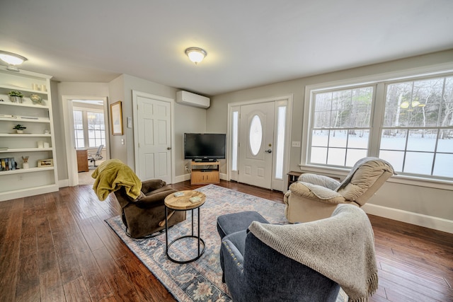 living area with a wall unit AC, baseboards, and dark wood finished floors