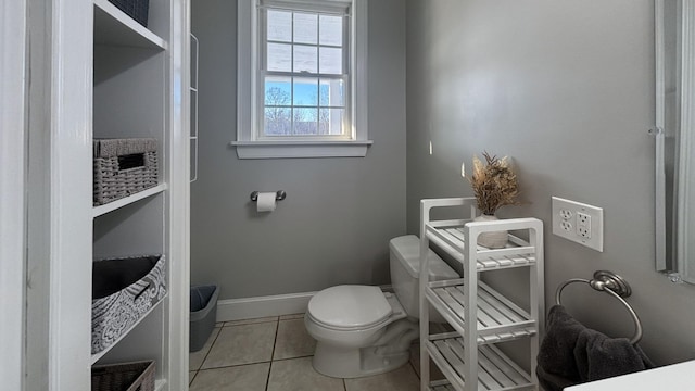 bathroom with baseboards, toilet, and tile patterned floors