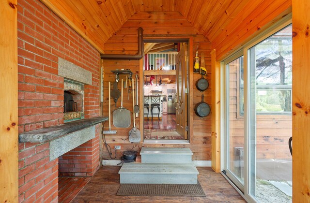 interior space with lofted ceiling, wood ceiling, wooden walls, and wood finished floors