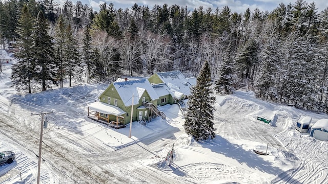 snowy aerial view featuring a view of trees