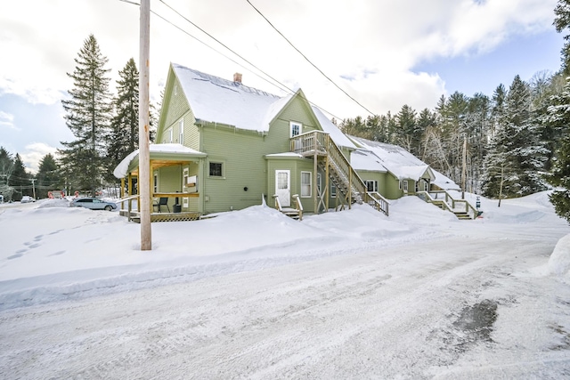 snow covered property with stairway