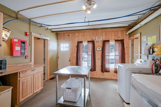 washroom with washer and dryer, laundry area, light colored carpet, and wooden walls