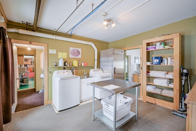 washroom with carpet floors, washer and clothes dryer, and a sink