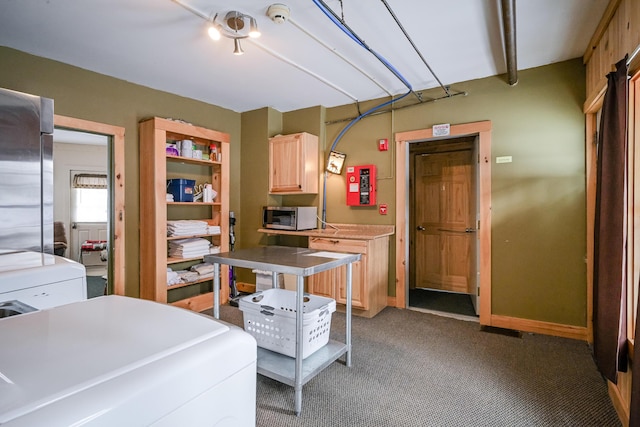 kitchen featuring stainless steel appliances, carpet, washer / dryer, and light brown cabinetry