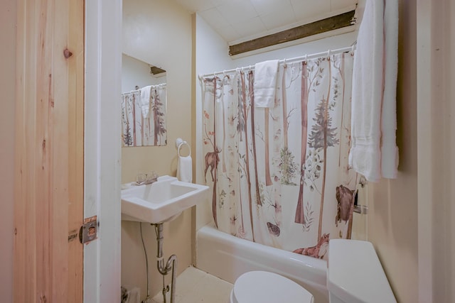 bathroom featuring a sink, toilet, and shower / tub combo with curtain