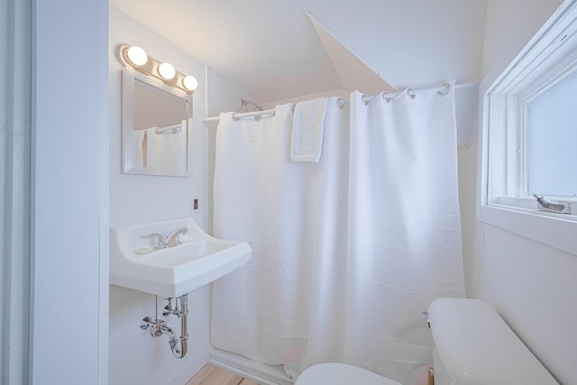 full bath with a shower with curtain, a sink, and toilet