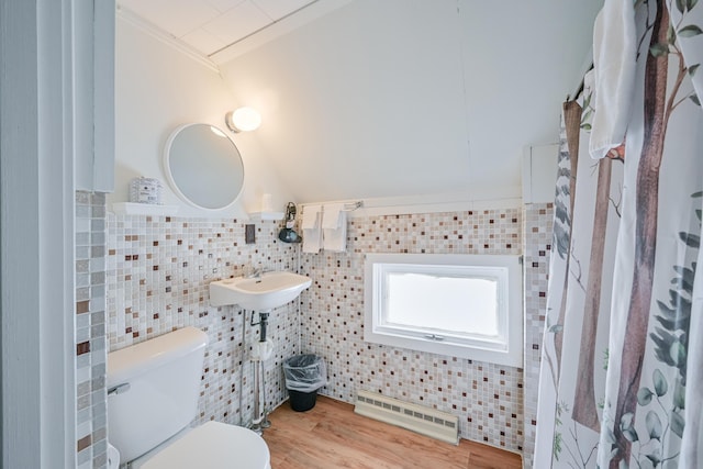 bathroom featuring tile walls, toilet, ornamental molding, a sink, and wood finished floors