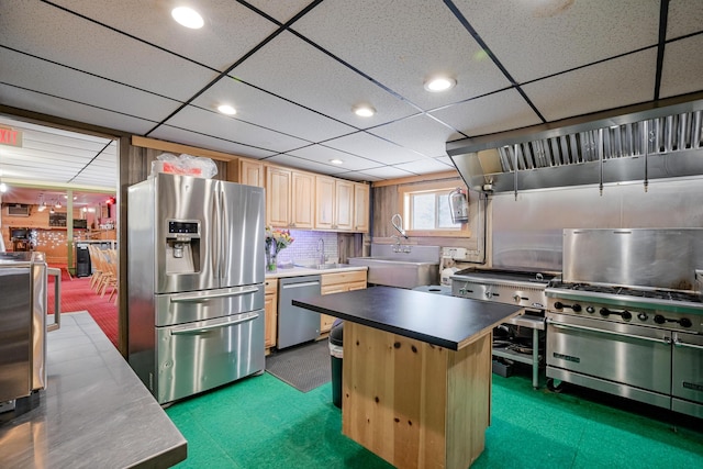 kitchen featuring light brown cabinets, appliances with stainless steel finishes, a sink, and a center island